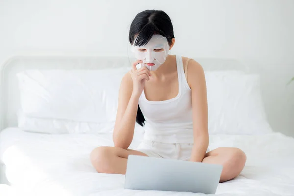 아름다운 침대에서 노트북 컴퓨터로 마스크를 미녀는 집에서 마스크를 착용하고 건강을 — 스톡 사진