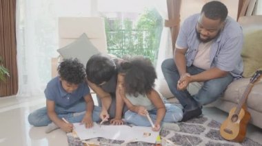 Anne ve babayla mutlu bir aile renkli kalemlerle çizim yapan çocuklar ve evde birlikte oturma odasında, öğrenim için aktivite ve hobi, eğitim kavramı..