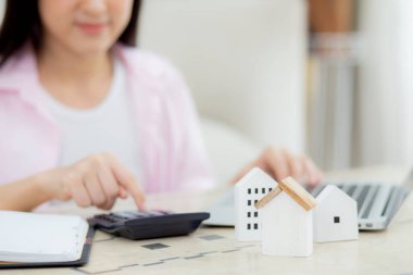Oturan, planlayan, hesap makinesi ve konut, konut sigortası ve konut, kredi ve ikamet bütçesi, iş ve mülk konsepti ile birlikte masraf ve ipotek hesaplayan kadınların yakın elleri.