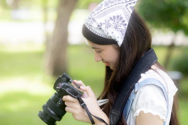 公園でリラックスするために写真を撮るカメラを使用して美しい幸福若いアジアの女性 庭で写真を撮る女の子の趣味 探索と撮影写真 ライフスタイルと活動のコンセプト — ストック写真