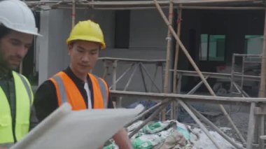Müteahhitlerden oluşan bir grup mühendis ve mimar, planlama projesinden işçiye planlama sahasına, şablona, inşaat sahasına, geliştirmeye ve yapıya bakıyorlar..