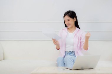 Genç Asyalı iş kadını dizüstü bilgisayarda çalışıyor ve kağıt üzerinde kâr elde etmek için grafik ve çizelge ararken, evde başarı elde etmek için iş kadını yatırım ve gelir arıyor, bilgi verileri.