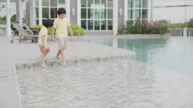 Rahatlamak için koşan ve havuz başında eğlenen mutlu çocuklar, eğlenceli, yaz ve tatil, açık hava aktiviteleri, tropikal tatiller, yaşam tarzları konsepti.