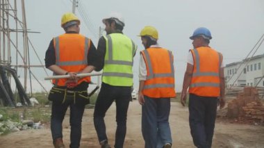 Grup mimarı ve müteahhiti inşaat sahasındaki konut, müteahhit ve işçi tartışması ve planlama, mühendis konsepti için dijital tablet bilgisayarı gezdirip araştırıyorlar..