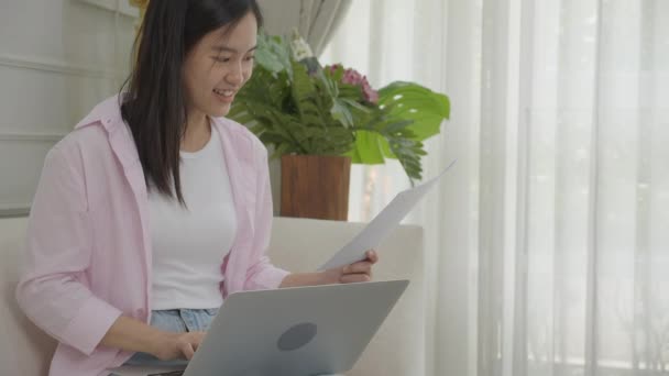 Genç Asyalı Kadını Dizüstü Bilgisayarda Çalışıyor Kağıt Üzerinde Kâr Elde — Stok video
