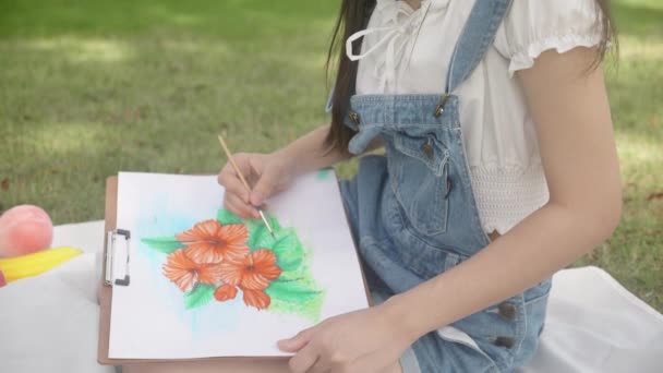 Młoda Azjatycka Kobieta Siedzi Rysunek Kolorowym Pędzlem Podczas Wypoczynku Parku — Wideo stockowe