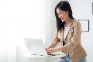 Young asian businesswoman working on laptop computer on desk at home office, freelance looking and typing on notebook on table, lifestyles of woman studying online, business and education concept.