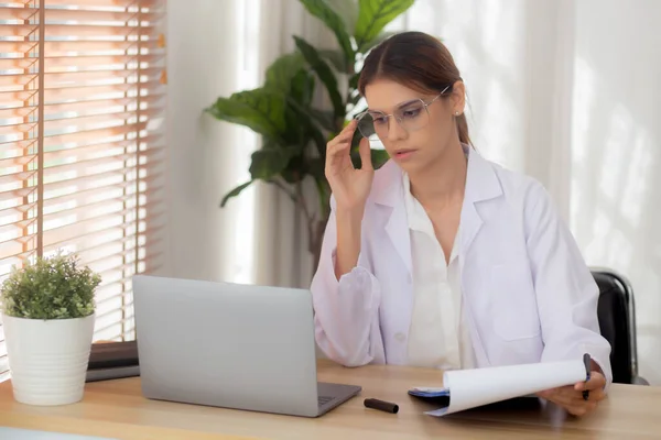 Young Woman Doctor Using Laptop Computer Looking Document Paper Patient — Foto de Stock