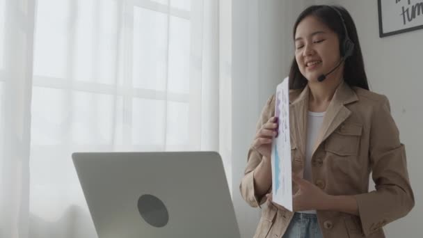 年轻的亚洲女商人用笔记本电脑在网上举行视频会议 女商人用视频通话开会并展示财务 通信概念的图表报告 — 图库视频影像