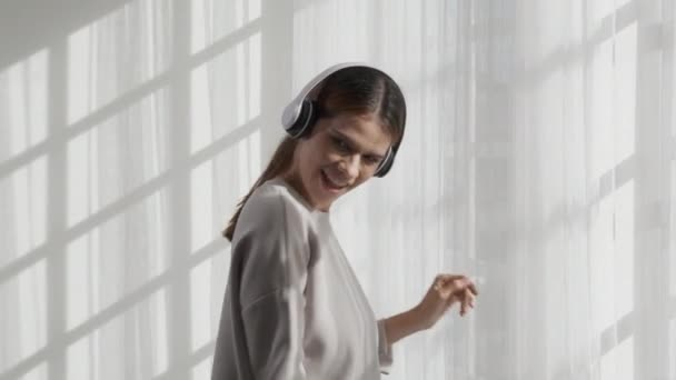 Gelukkige Jonge Vrouw Draagt Koptelefoon Muziek Luisteren Tijdens Het Dansen — Stockvideo