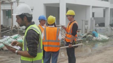 İnşaat alanında teftiş ve araştırma projesi konut ve grup müteahhitleri toplantısı için dijital tablet arayan mimar, inşaatçı ve işçi planlaması ve tartışması, mühendis konsepti.