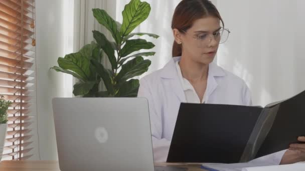 Young Woman Doctor Working While Looking Document Folder Patient Illness — Video Stock