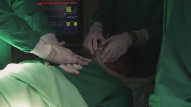Doktor ve cerrahın elleri göğsüne kalp masajı yapıyor. Hastanedeki ameliyatta, kardiyolojide ve tedavide, acil ve canlandırmada, tıbbi ve sağlıkta acil kalp masajı yapılıyor..