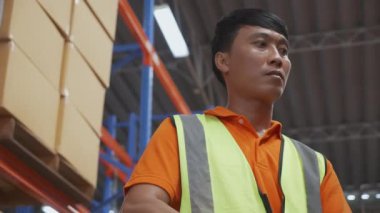 Young asian man driving vehicle move cargo for transportation and distribution in the warehouse at factory, worker working in storehouse, shipping and industrial, logistic and freight concept.