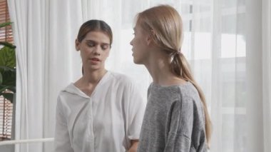 Young caucasian woman depressed while friends encourage in the bedroom at home, relation and assistance with cheering while unhappy and worried, lifestyles and feeling emotion with consoling concept.