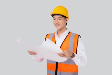 Portrait young asian man is engineer wearing helmet holding and looking blueprint with confident isolated on white background, handsome male is architect or contractor, worker or labor concept.