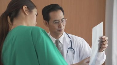 Group of team doctors checking and examining x-ray film about bone and skeleton of patient for checking disease while discussion at hospital, doctors and assistant talking together, medical concept.