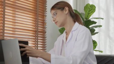 Young woman doctor working while looking document folder about patient illness on clipboard at clinic, female looking report paperwork for examining at hospital, one person, medical concept.