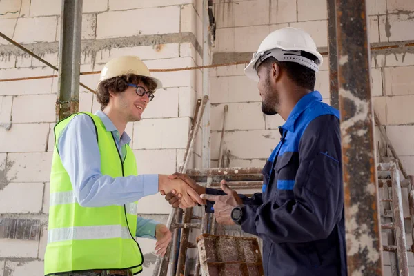 Team of young foreman and worker handshake with hands for teamwork for achievement, engineer and construction site, architect shaking hand for success about agreement and deal together.