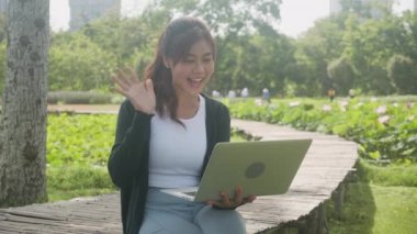 Beautiful young asian woman sitting and using laptop computer for video call conference online talking with colleagues, girl using notebook on social media, lifestyles and communication concept.