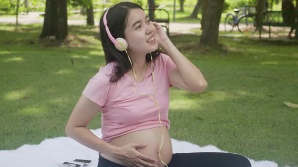 Счастье Молодой Азиатской Женщины Беременной Сидя Слушая Музыку Отдыха Парке — стоковое видео