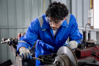 Young man sanding or iron at industrial factory, mechanic working job while polish metal, male having skill built steel with tool, engineer and equipment, labor and steelworks, industry concept.
