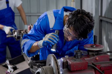 Young man sanding or iron at industrial factory, mechanic working job while polish metal, male having skill built steel with tool, engineer and equipment, labor and steelworks, industry concept.