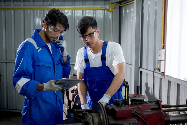Supervisor training with young man sanding or iron at industrial factory, mechanic working job while polish metal, male having skill built steel with tool, labor and steelworks, industry concept.