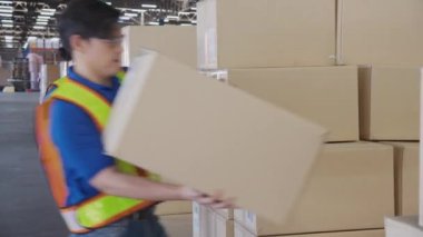 Delikanlı, fabrikadaki depoda nakliye ve dağıtım için kutu destesi taşıyor. Depoda çalışan işçi, lojistik ve ulaşım, endüstriyel ve kargo konsepti..