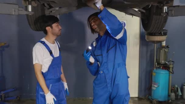 Dois Jovens Mecânico Segurando Lanterna Carro Reparação Garagem Com Profissional — Vídeo de Stock