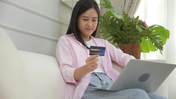 Молода Азіатка Сидить Дивані Використовуючи Покупки Ноутбуків Онлайн Кредитною Карткою — стокове відео
