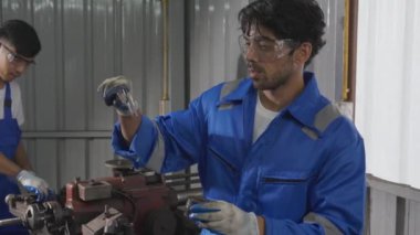 Young man sanding or iron at industrial factory, mechanic working job while polish metal, male having skill built steel with tool, engineer and equipment, labor and steelworks, industry concept.