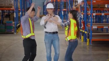 Genç işçi ve yönetici birlikte dans ederken başarı ya da zafer fabrikadaki depoda çalışmak, erkek ve kadın mutluluğu eğlence ve keyif, lojistik ve ulaşım, nakliye konsepti.