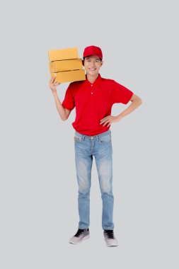 Young asian man in uniform red and cap standing carrying box stack isolated white background, employee holding cargo or package, courier and delivery, transportation and service, logistic and cargo.