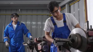 Metal, mühendis ve ekipman, işçilik ve çelik fabrikası, sanayi konsepti, sanayi konsepti cilalarken iki genç adam zımparalıyor veya demir kırıyor..