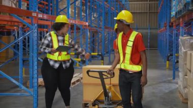 Delikanlı ve kadın, fabrikadaki depoda nakliye ve dağıtım için kargo taşıyıp taşıyorlar. Depoda çalışan işçiler, nakliye ve sanayi, lojistik ve nakliye konsepti..