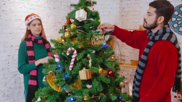 家で楽しむと一緒にクリスマスツリー上の幸せな若いカップルの装飾や準備の飾り 興奮して男性と女性の装飾祭りのクリスマス Xmasと新年や休日のコンセプト — ストック動画