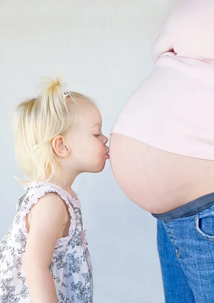 สาวน้อยจูบท้องของแม่ — ภาพถ่ายสต็อก