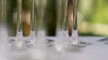 Parktaki açık büfe resepsiyonunda masanın üzerinde duran cam şarap kadehlerinin yakın çekimleri.