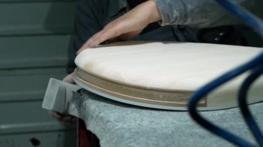 Erkek ellerinin zımpara kağıdıyla müzik aletini öğüttüğü yakın çekim. Bandura yapımı - Ukrayna ulusal müzik enstrümanı.