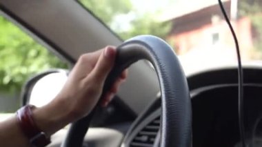 Direksiyon simidinin kayma videosu. Bir adam araba sürüyor ve direksiyonu elleriyle tutuyor..