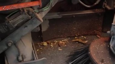 Sokak temizleme makinesi şehir caddesini fırçalarla temizliyor. Sokakları ve yol yüzeylerini temizlemek için ekipman. Sonbahar sokağından dökülen sarı yaprakları temizleyen makine fırçası.