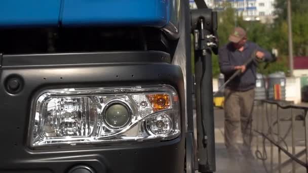 Mężczyzna Myje Dużą Ciężarówkę Wężem Myjni Samochodowej Robotnik Myje Śmieciarkę — Wideo stockowe