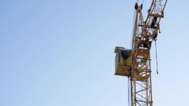  Gökyüzünün arka planına karşı çok katlı bir binanın inşaatı sırasında yakın çekim vinci.