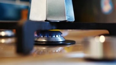 Yakın çekim gaz ocağı ev mutfağında bir gayzer kahve makinesini ısıtıyor..