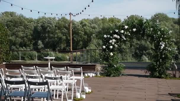 婚礼上漂亮的装饰 许多棕色的木制椅子在婚礼装饰的背景下排成一排 婚礼拱门后面的空座位给客人 — 图库视频影像