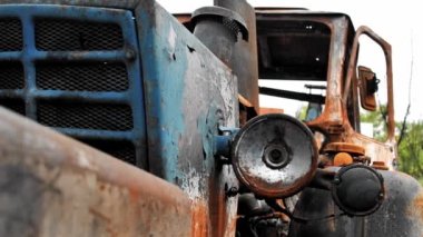 Felaket, yangın ve askeri hava saldırısından sonra yanmış bir traktörün kırık farının yakın çekimi. Rus Ukrayna 'nın roket ve topçu bombardımanı sonucu sivil araçlar etkilendi.