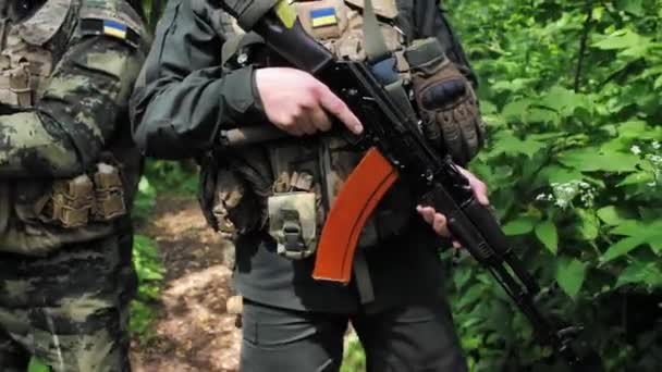 軍事任務中に兵士の手の中にカラシニコフのアサルトライフルのクローズアップ 軍の特殊部隊のグループが掃引を行っている 戦争中のパトロール ウクライナ2022年 ロシア戦争 — ストック動画