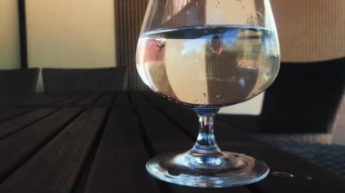 Bardakta maden suyu olan köpükler. Masada bir bardak su var..