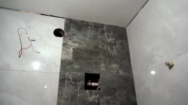 Tadilat sırasında boş bir banyo. Yeni yapıştırılmış seramik fayanslar ve dairenin tadilatı sırasında yeni tesisat. Bitmemiş yenileme.